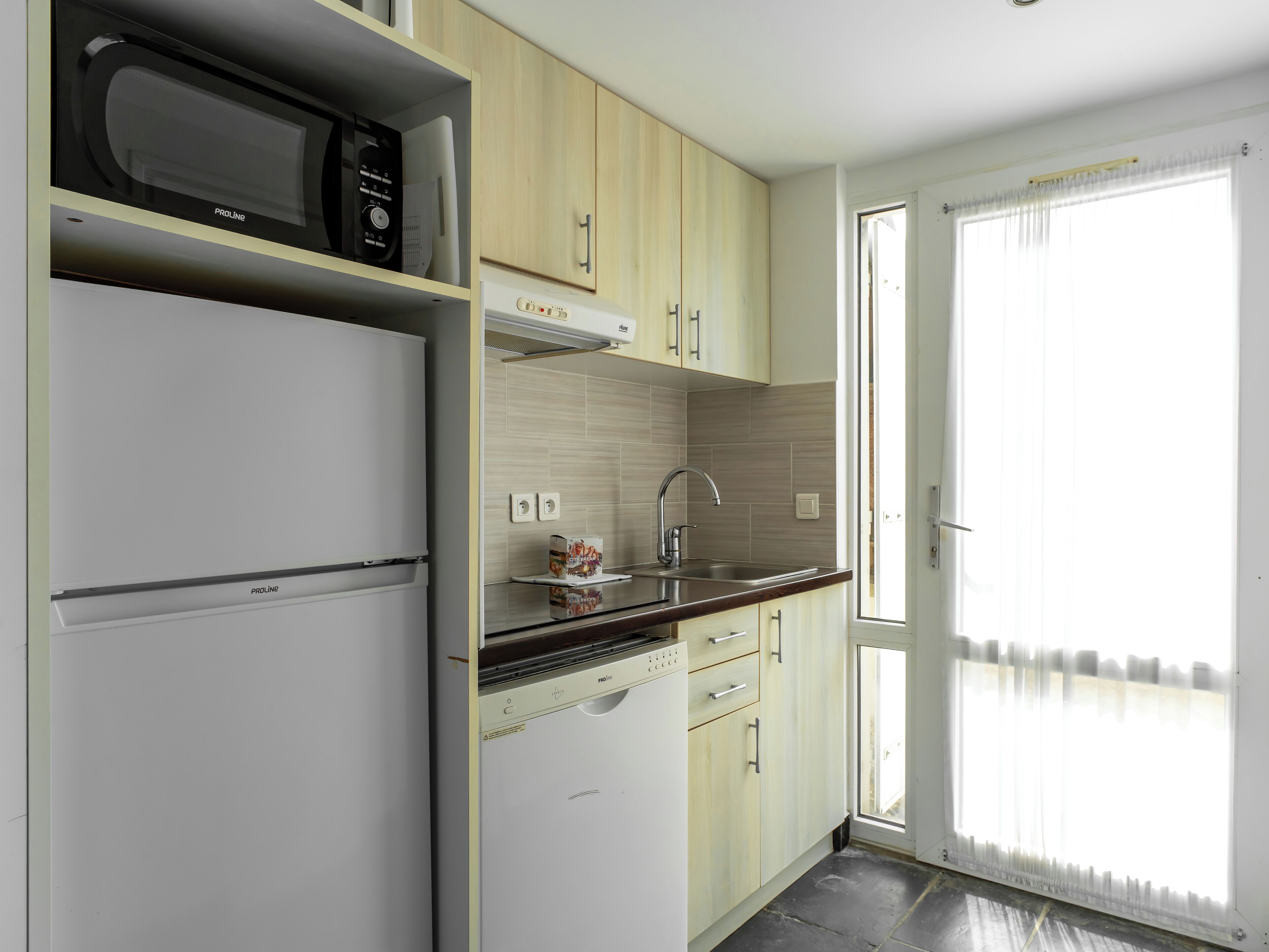 A modern kitchen with a built-in microwave, a dishwasher, and a sink.