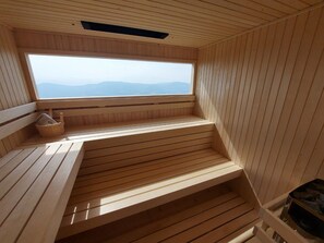 Relax in a serene sauna with a view of the distant mountains.