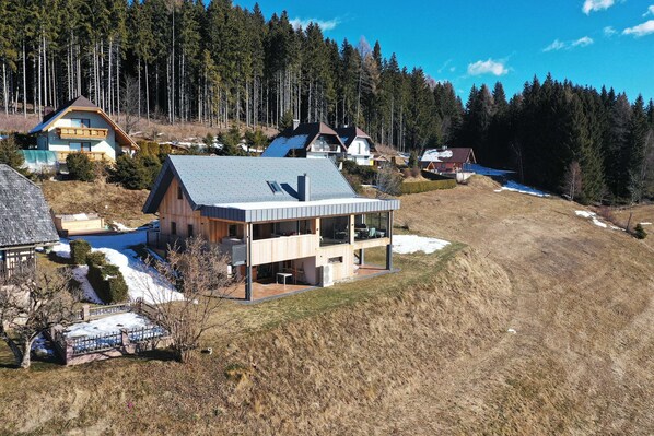 Enjoy the serene surroundings from the large balcony, surrounded by a forested area.