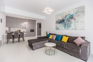 Leilighet – deluxe | Oppholdsområde | En 98-tommers LCD-TV med kabel-kanaler samt TV