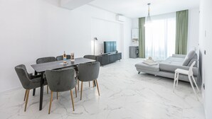 A modern living room with a dining area, a grey sofa, and a TV. - Sea On (Navodari)