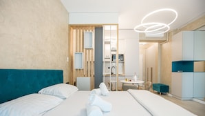 A modern hotel room with a large bed, a desk, and a seating area. - Sea On (Navodari)