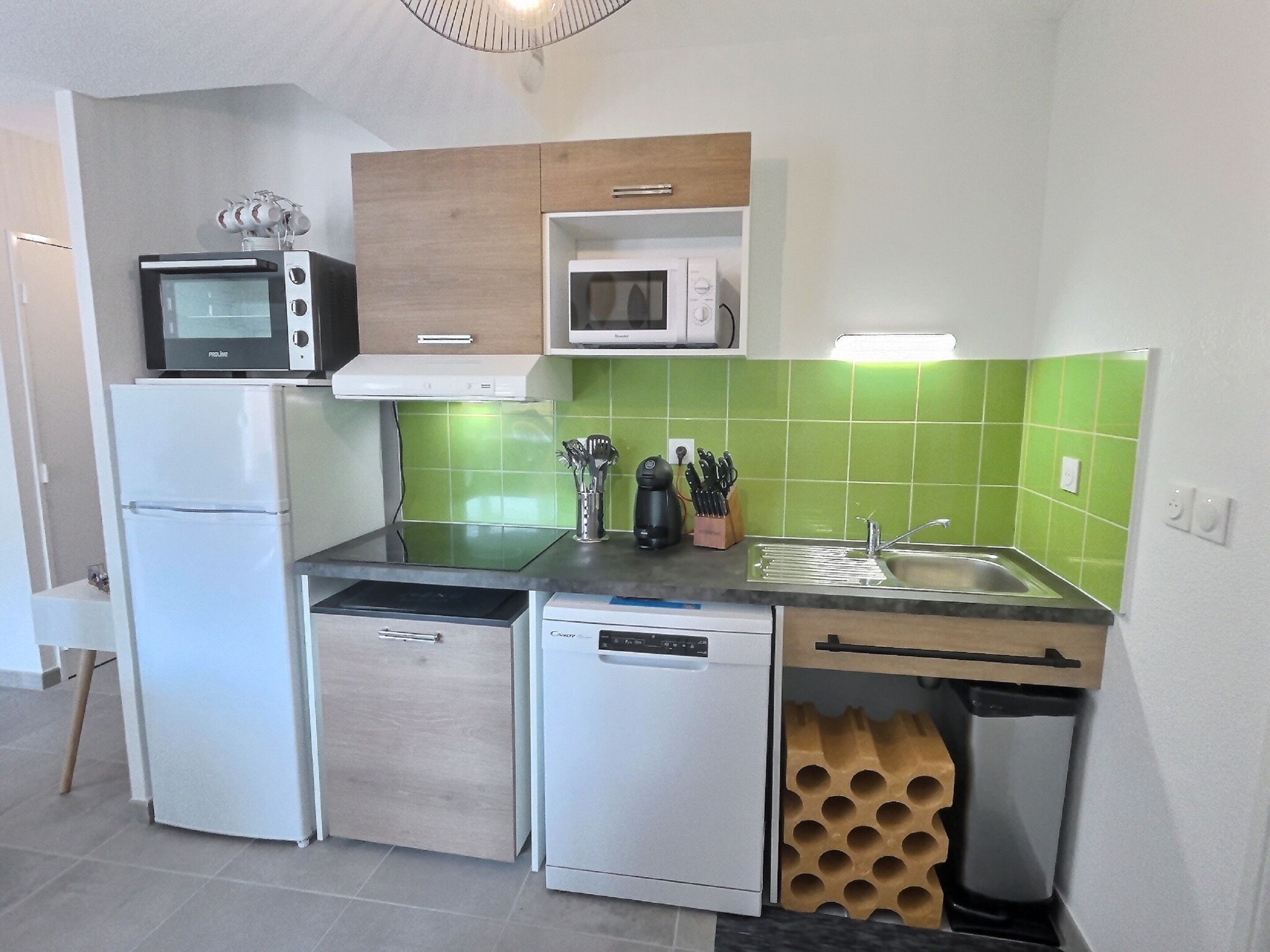 Een functionele keuken met een magnetron, oven en vaatwasser.