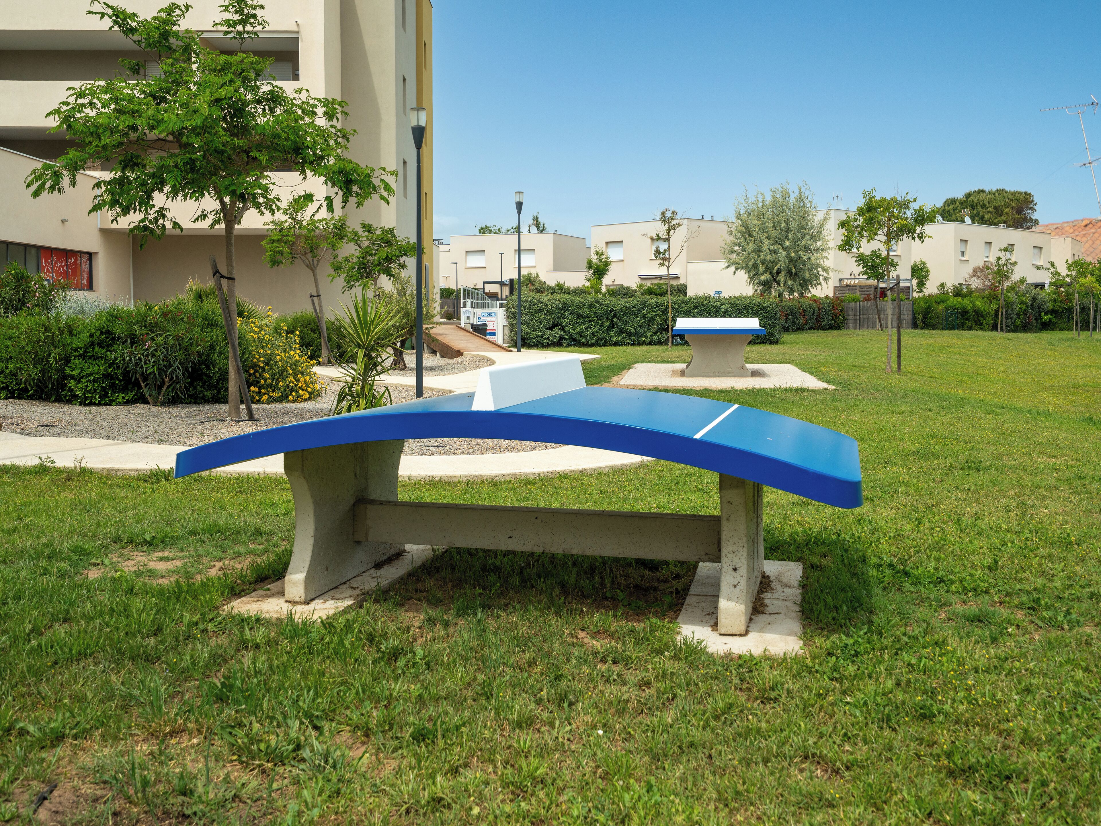 Ein Park mit einer blauen Bank und einem Steintisch.