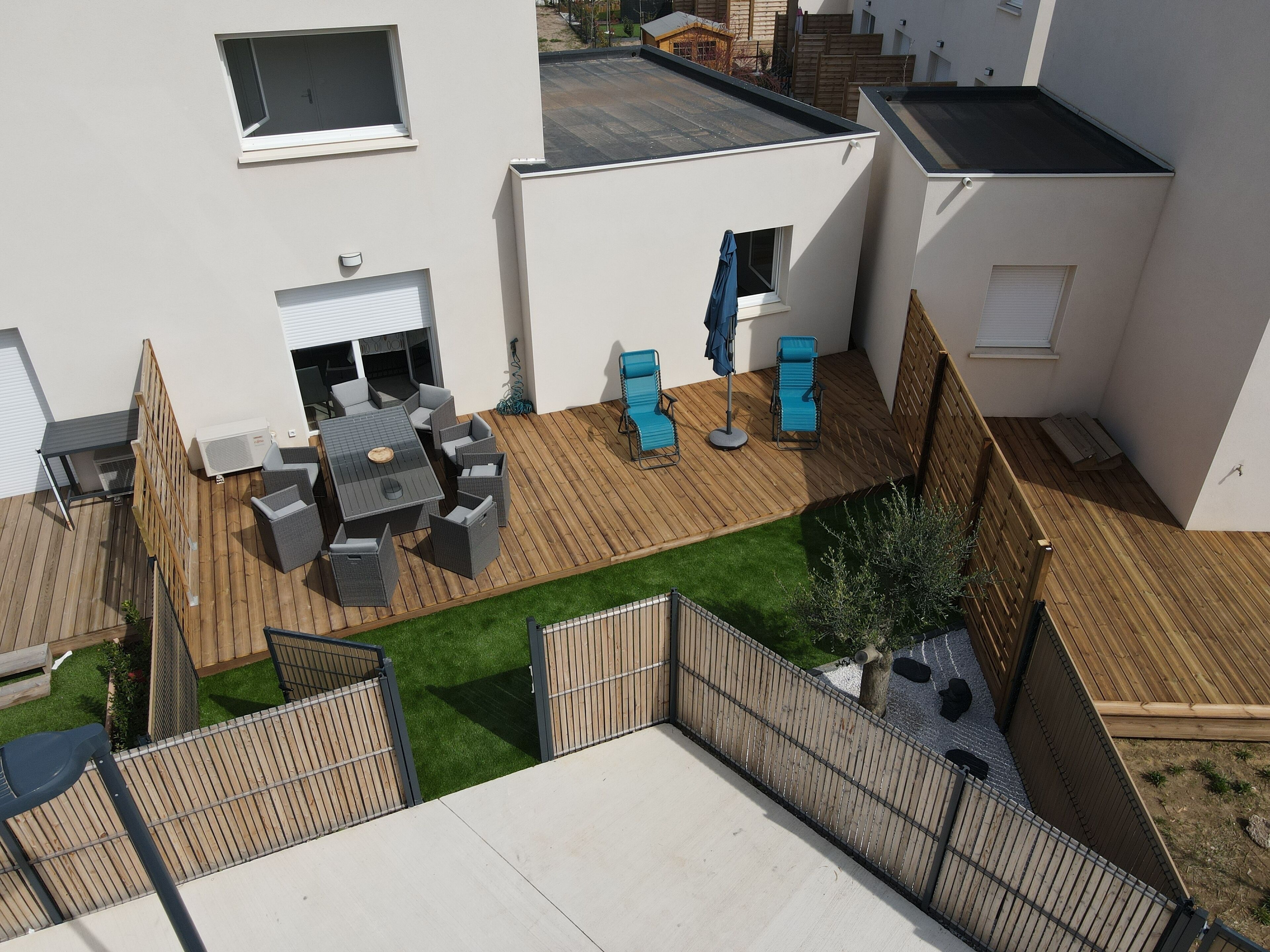 Een terras op het dak, met een eethoek, zitplaatsen buiten en een kleine tuin.