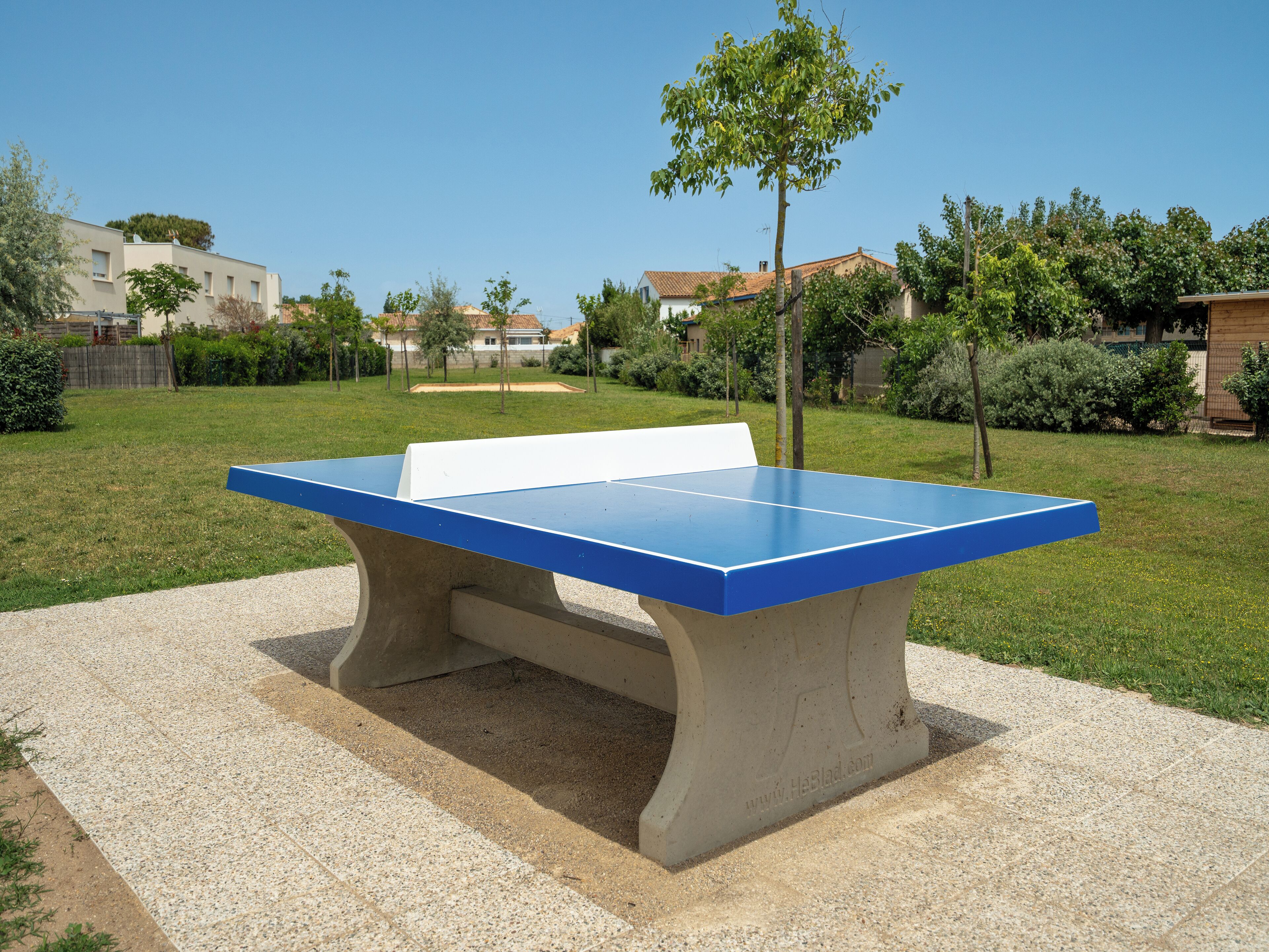 Mesa de ping pong en un entorno exterior con cielo despejado.