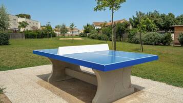 Mesa de ping pong en un entorno exterior con cielo despejado.