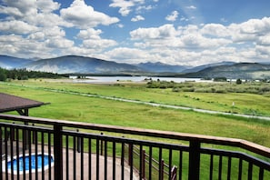 A pool area with a view of a lake and mountains.