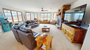 A spacious living room with leather sofas, a wooden coffee table, and a stone fireplace. - Lake View! 3 Kings. Elevator, Hot Tubs. On Lake Rec Path. Walk to Dining (Frisco)