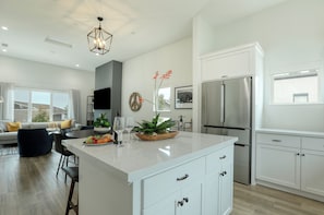 A modern kitchen with white cabinetry, a large island, and stainless steel appliances. - Shell Beach Modern with Ocean Views, Pet Friendly (Shell Beach)