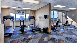 Ein Fitnessraum mit Laufbändern, Crosstrainern und Fahrrädern.