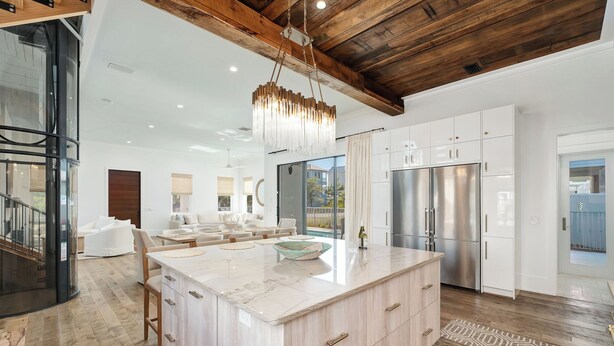 A spacious kitchen with a large island, modern appliances, and a high ceiling with exposed beams. - Coastal Dream|Short Walk to Beach Access|Private Pool|Gulf Views|Golf Cart (Santa Rosa Beach)