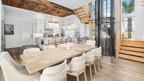 A spacious kitchen with a central island, wooden ceiling beams, and large windows. - Coastal Dream|Short Walk to Beach Access|Private Pool|Gulf Views|Golf Cart (Santa Rosa Beach)