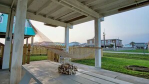 A covered outdoor area with a wooden table and a hammock. - Serenity Sol ※ Surfside Charmer Near Beach & Jetty (Surfside Beach)