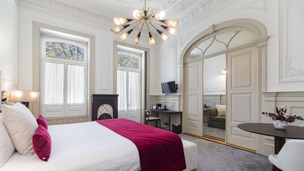 Une chambre d’hôtel dotée d’un grand lit, d’un bureau, d’une télévision et d’un coin salon.