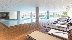 Een binnenzwembad en ligstoelen