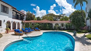Una piscina con lettini e un'area patio coperta.