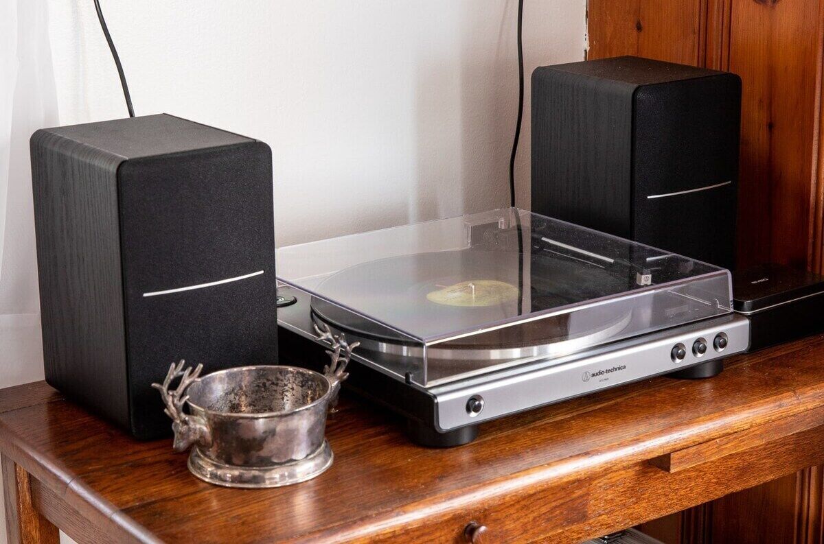 A turntable with two speakers on a wooden table.