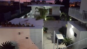 A residential building with a flat roof, a balcony, and a staircase leading to an upper floor. - B&B Villa Colomba (Torre del Greco)