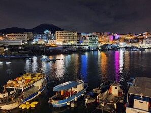 Eine Marina mit vertäuten Booten, eine Stadtlandschaft im Hintergrund und ein Berg.