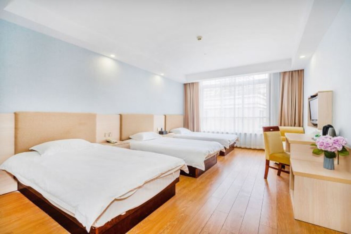 Ein Hotelzimmer mit zwei Betten, einem Schreibtisch und einem Stuhl.