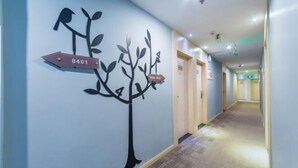 A hallway with directional signs and a wall-mounted tree decoration. - Home Inn Huayi Hotel (Foshan Daliang Huagai Road Pedestrian Street Qinghuiyuan Branch) (Foshan)