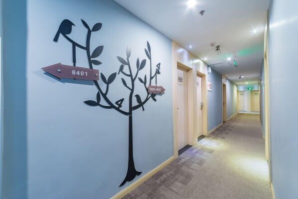 A hallway with directional signs and a wall-mounted tree decoration. - Home Inn Huayi Hotel (Foshan Daliang Huagai Road Pedestrian Street Qinghuiyuan Branch) (Foshan)