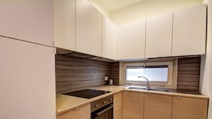 A compact kitchen with a window, a sink, and a stove. - Appartamento Ariel   La Perla del Mare di Polignano (Polignano a Mare)