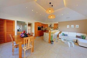 Relax in this stylish living space with a central kitchen island, dining table, and comfortable seating area.