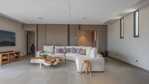 Een ruime woonkamer met een grote hoekbank, een houten salontafel en een minimalistisch design.