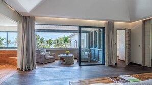 A modern hotel room with a balcony, wicker furniture, and a wooden floor. - Villa K (3/4 Rooms) Luxury villa (Anse Des Cayes)