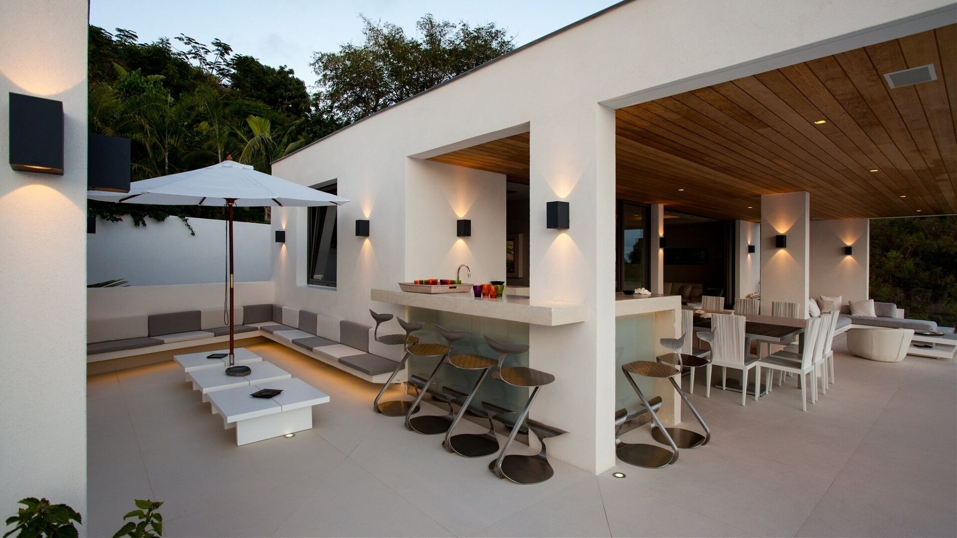 An outdoor patio with a dining area, seating, and a bar.