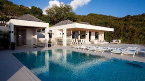 A modern poolside area with a clear blue pool, white lounge chairs, and a covered seating area with tables and chairs. - Vitti (4/5 Rooms) Luxury villa (Gustavia)