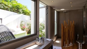 A modern bathroom with a large window, a sink with a mirror, and a shower area with wooden elements. - Vitti (4/5 Rooms) Luxury villa (Gustavia)