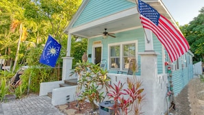 Une maison avec un porche, un drapeau américain et un drapeau de la République des Conch.