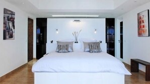 Un dormitorio moderno con una cama grande, dos mesitas de noche y una lámpara de pared.