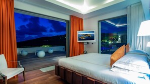 Une chambre moderne avec un grand lit, une télévision et une vue sur le ciel nocturne.