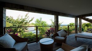 A covered outdoor seating area with wicker furniture and a view of the ocean. - Beautiful Ushuaia Luxury villa (Flamands)