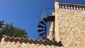 A stone building with a spiral staircase leading to an upper level. - Villa de Bonaire, Alcudia, large garden + pool, close to the beach, WiFi, for 8 people (Alcudia/Bon Aire)