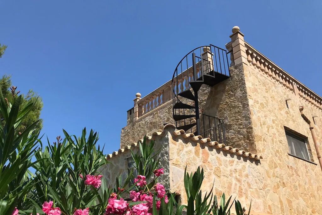 Un edificio de piedra con una escalera de caracol y un balcón.