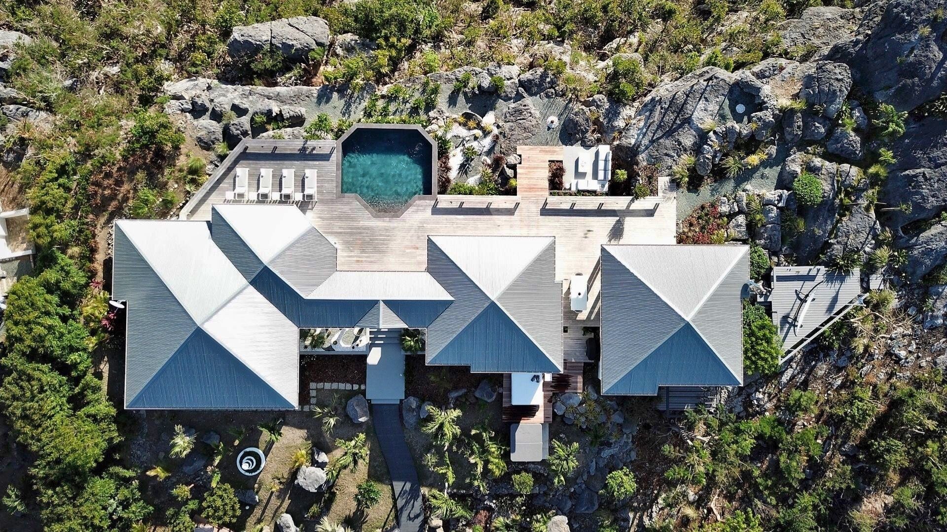 A modern resort with a pool, multiple guest rooms, and a landscaped garden.