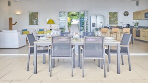 Een moderne eetruimte met een grote tafel voor zes personen, omringd door stoelen.
