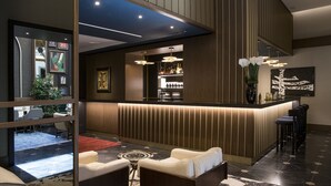 A modern lobby with a reception desk, seating area, and bar.
