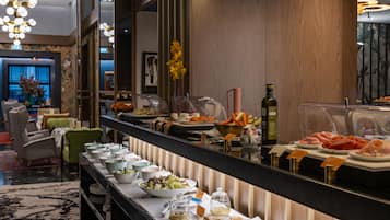 A buffet area with various food items and a mirror reflecting the space.