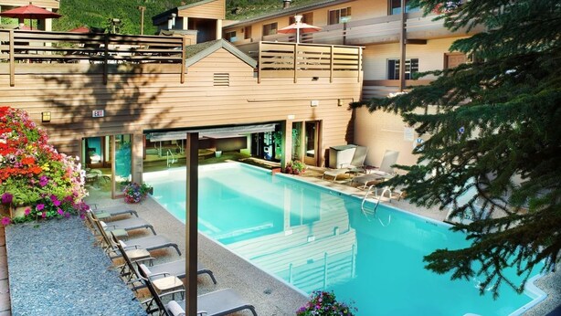 Ein Hotel mit Schwimmbad, Außenbereich und Blick auf die Berge.