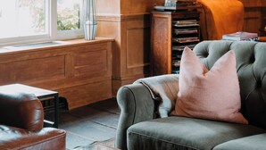 Una sala acogedora con chimenea, estantería y un sofá confortable.