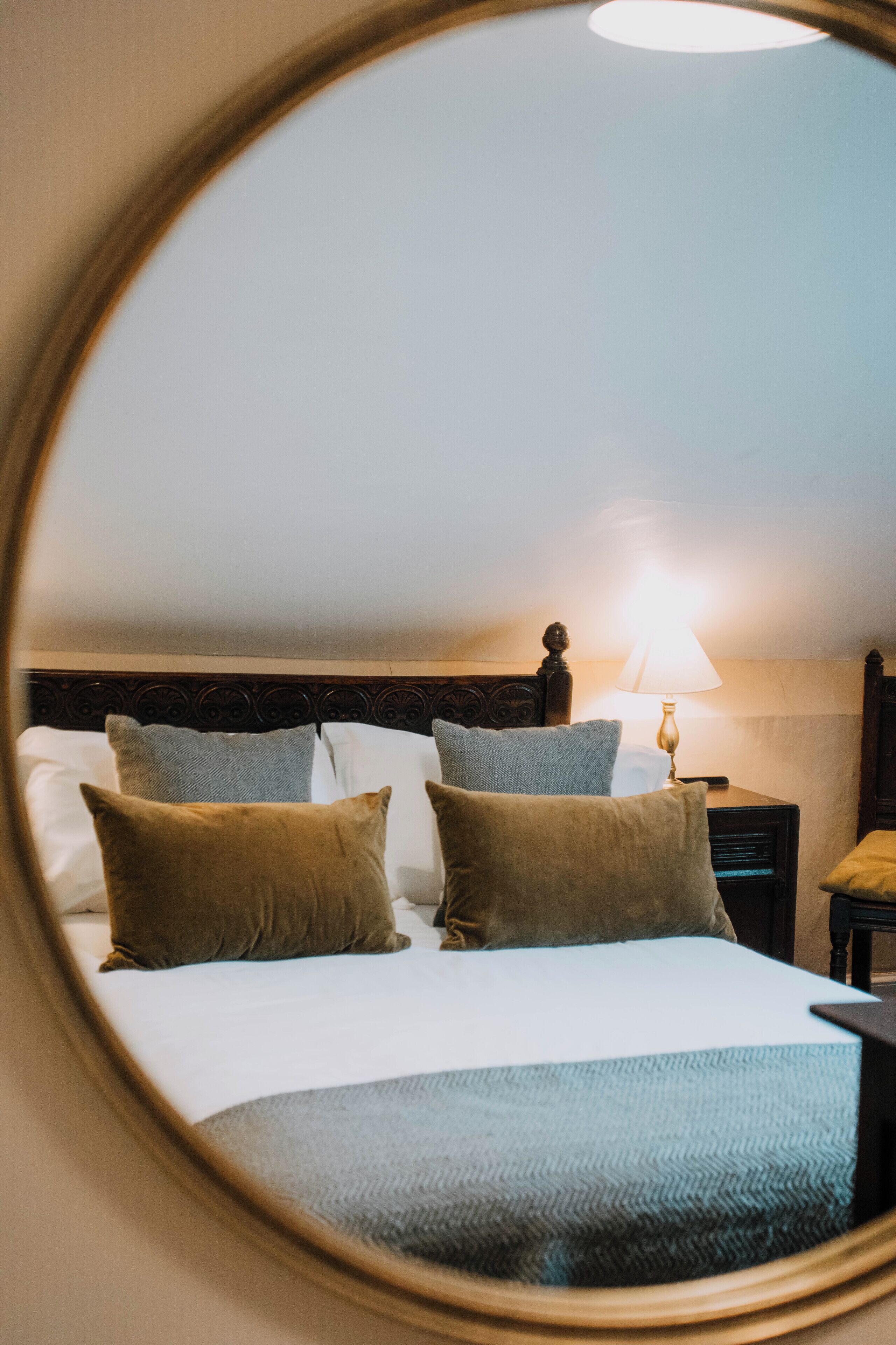 A bed with a headboard, a bedside lamp, and a nightstand.