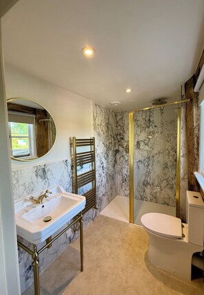 A bathroom with a marble sink, a glass-enclosed shower, a toilet, and a towel rack. - Three Cocks Hotel (Brecon)