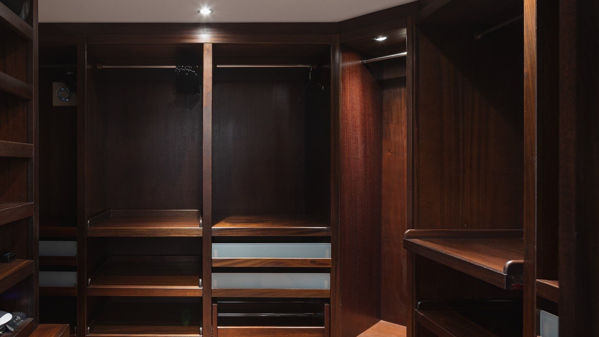 Un dressing en bois, doté de nombreuses étagères et d’un espace pour suspendre les vêtements.