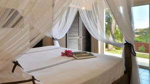 A bedroom with a bed, a window, and a view of greenery outside. - Kir Royal (1/4 Rooms) (Gustavia)